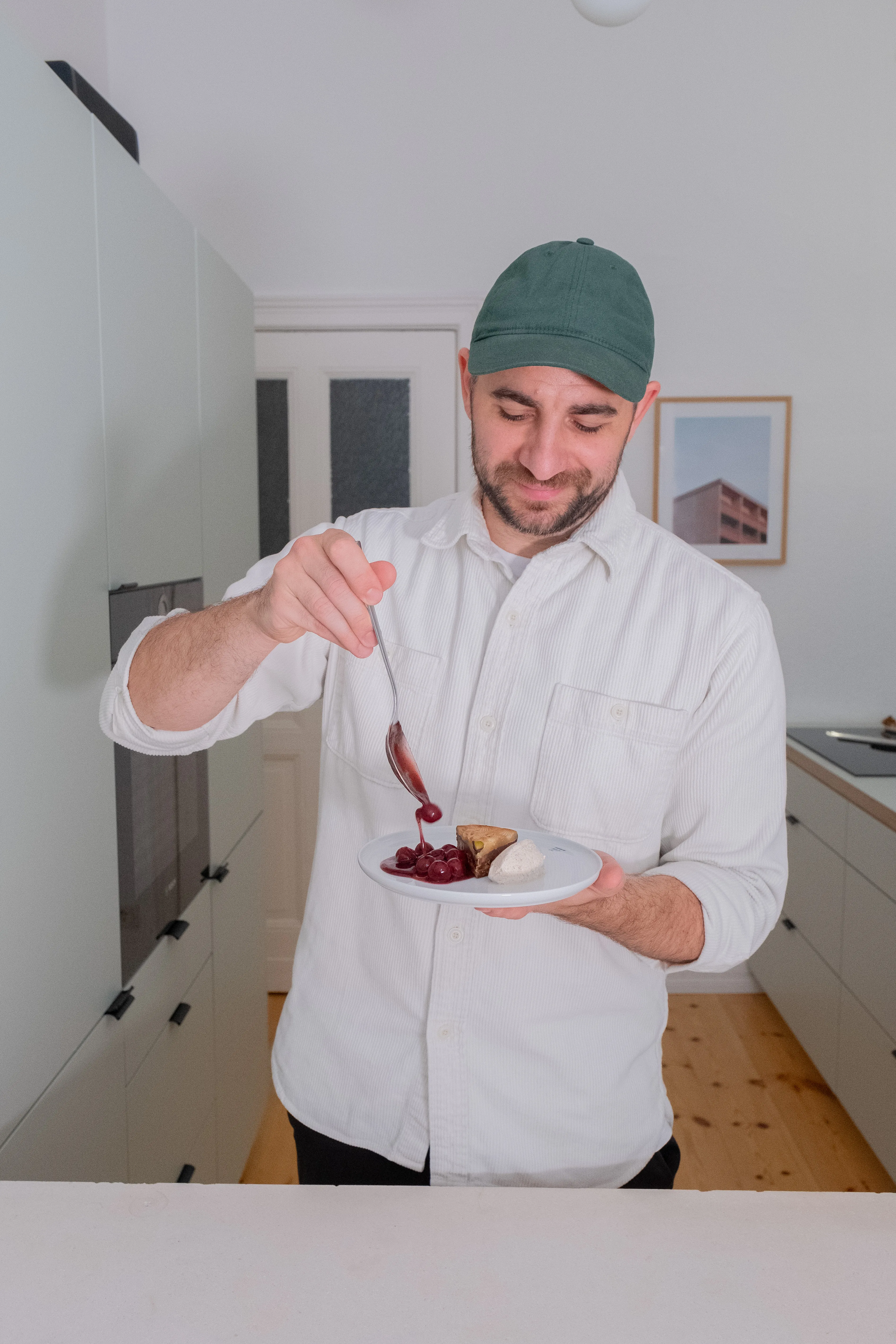 Fabian von About Fuel präsentiert Sawade-Torte mit Glühweinkirschen und Zimtsahne auf weißem Teller